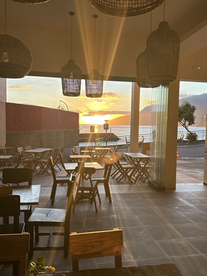 Sunset over the ocean, seen from inside Obsidian 17 through the open glass front