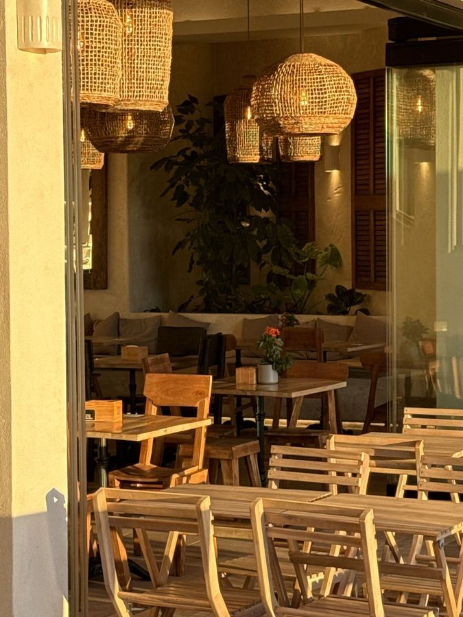 Evening light on the tables, wicker lamps and plants inside Obsidian 17